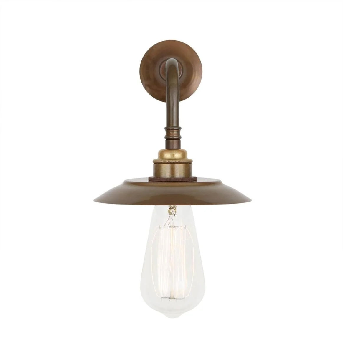 The Vintage Brass Industrial Sconce features an exposed bulb hanging from a round backplate and a shallow, wide metal shade in a brass finish. This made-to-order item has a 2-3 week lead time.