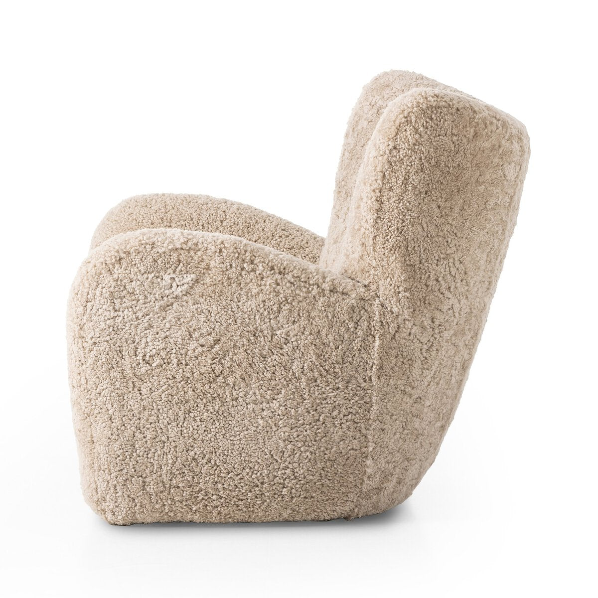 Side view of the Shearling Accent Chair - Beige featuring a high back, thick seat, and soft, ethically sourced beige shearling upholstery, set against a white background.