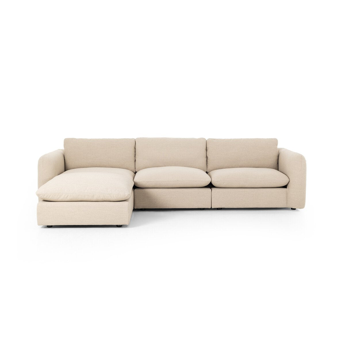 The Linen 3pc Sectional, shown in beige with a left-facing chaise lounge and low cushioned armrests, includes an ottoman. Its overall dimensions make it a comfy fit for any living space, set here against a plain white background.