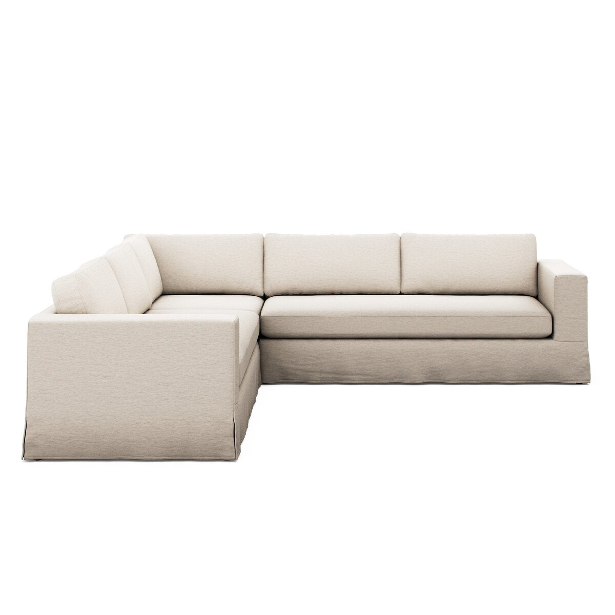 The Draped 3pc Sectional is a modern, light beige L-shaped sofa with clean lines, plush seat and back cushions, and a skirted base. Its oversized bench design seats several people, ideal for minimalist contemporary living rooms.