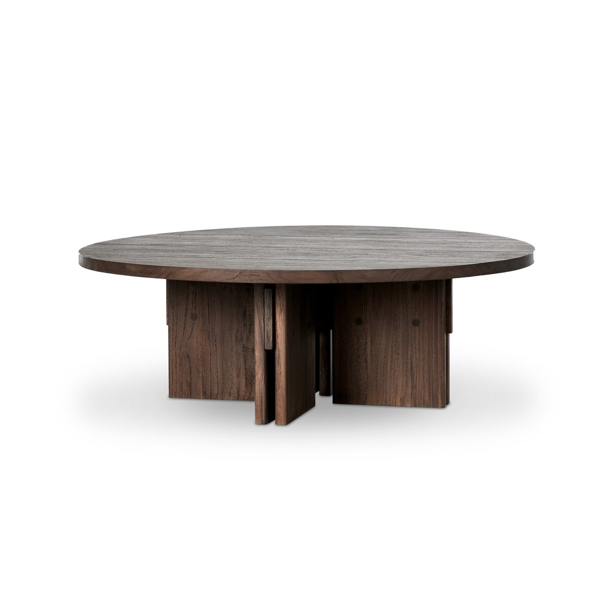 The Teak Outdoor Coffee Table is round with a toasted brown, dark wood finish. It features a thick tabletop and a modern geometric base made of interlocking vertical wood panels, perfect for outdoor spaces.