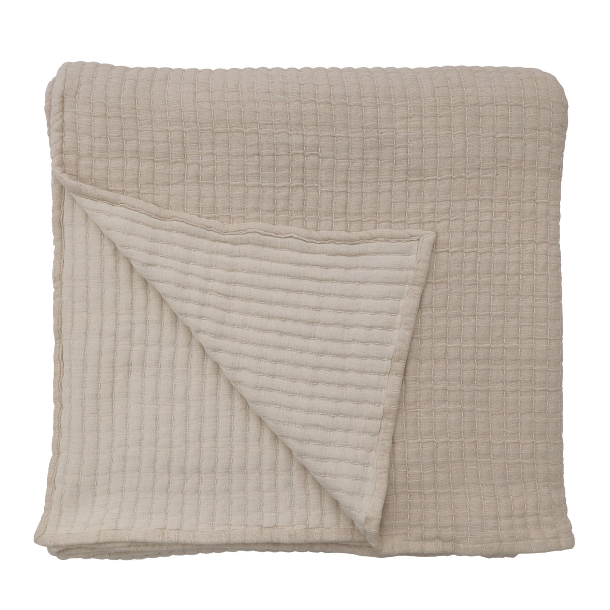 A Cream Cotton Oversized Throw Blanket in a light beige shade, featuring a textured, quilted grid-like design. The blanket measures 60 x 90 inches and is shown folded with one corner flipped over to reveal the same material and pattern on both sides.