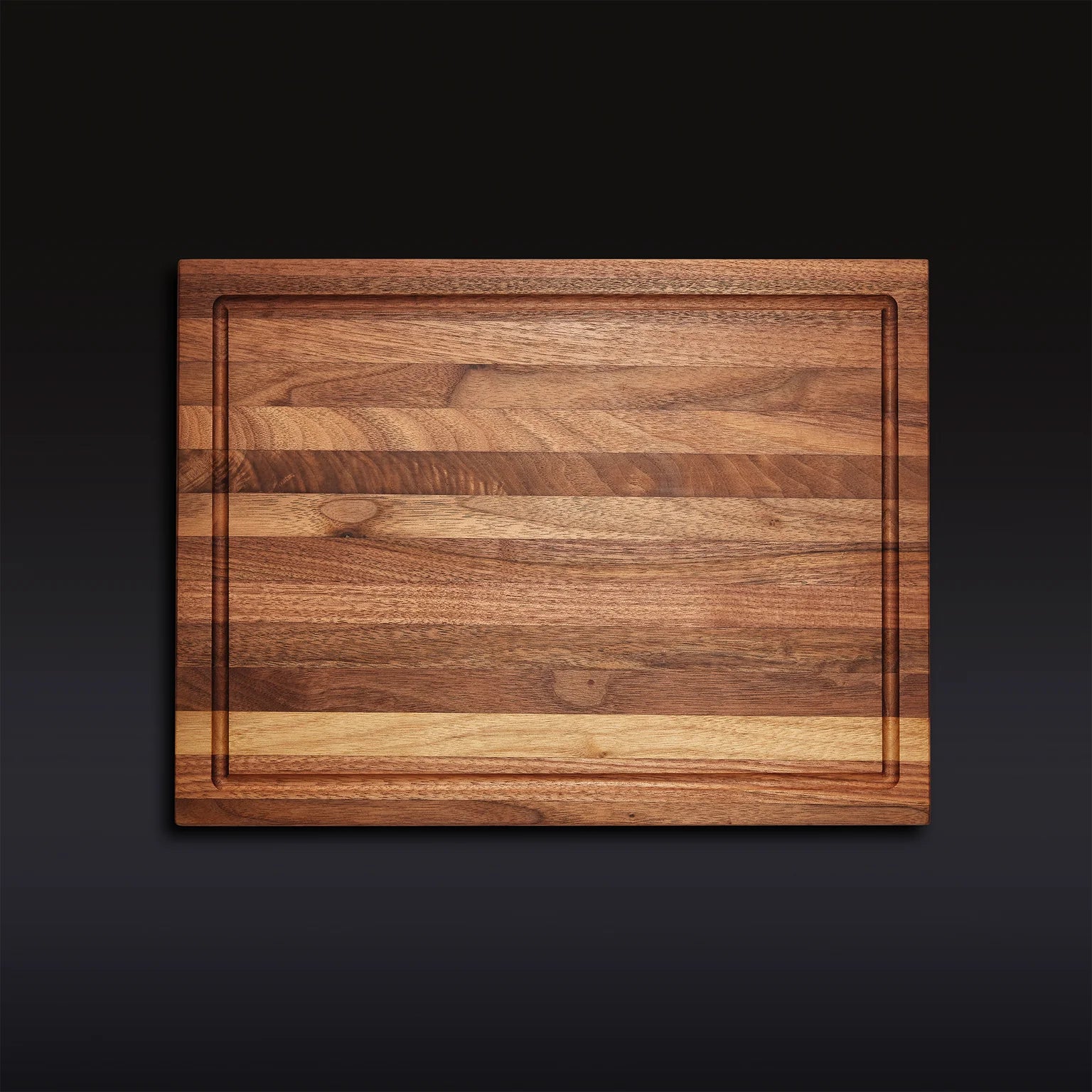 The Hexclad Cutting Board is a rectangular wooden board with light and dark grain patterns and an edge groove, displayed on a dark gradient background.